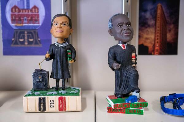 Sign that says “Bobbleheads of Supreme Court Justices Ruth Bader Ginsburg and Clarence Thomas.