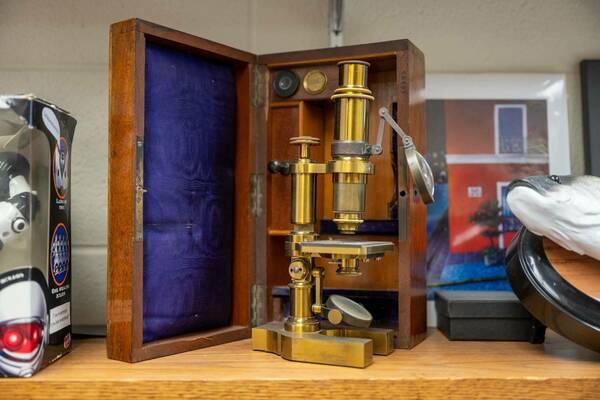 Photo of an old-fashioned microscope on display.